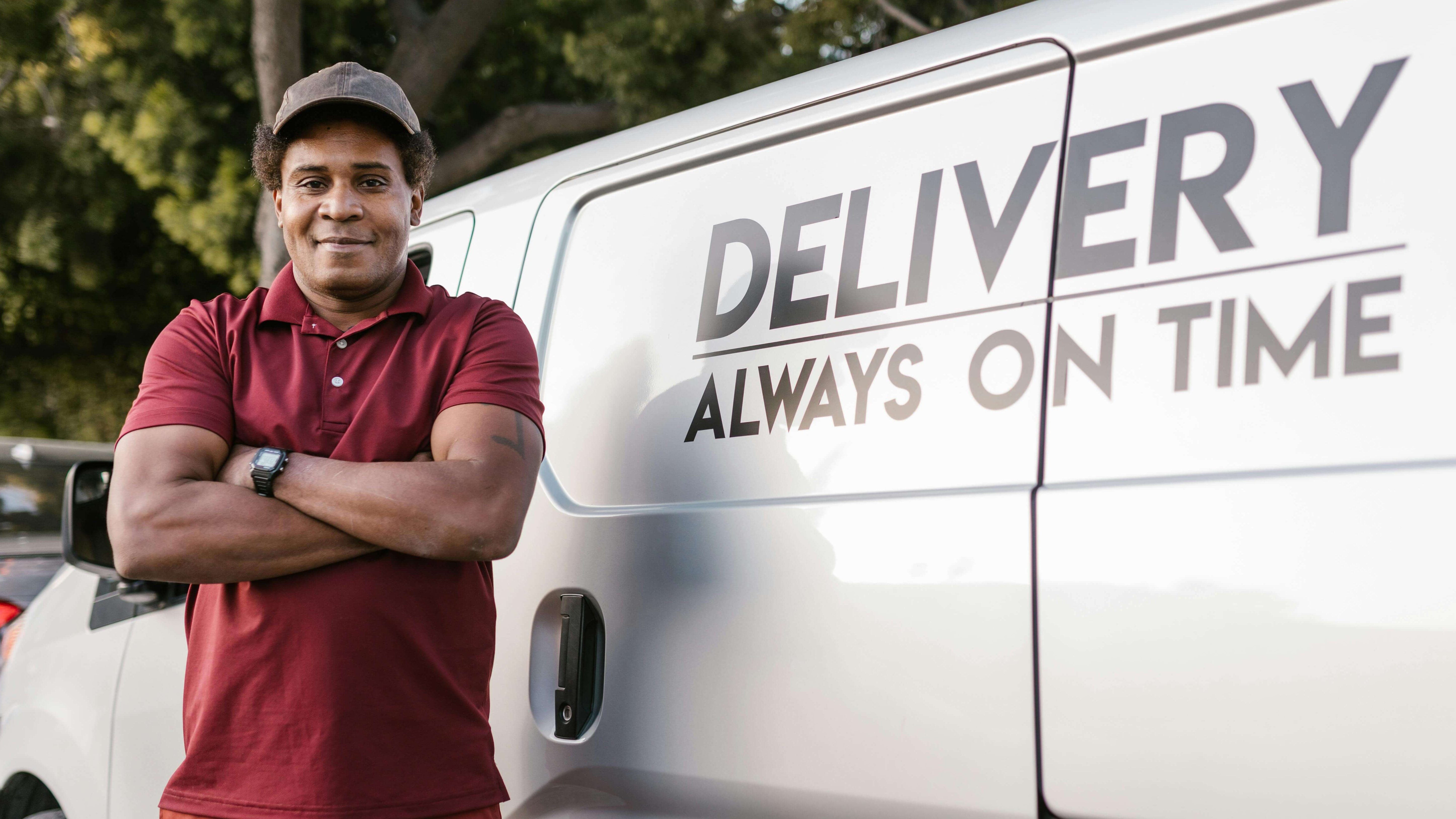 Livreur debout devant son fourgon de livraison rapide